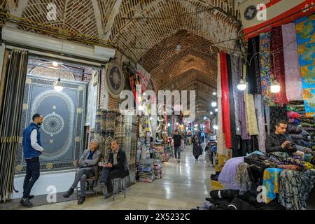 Urmia, Iran - 20 avril 2024 : hommes vendant des tapis et des tissus dans le Bazar historique d'Urmia, Iran. Banque D'Images