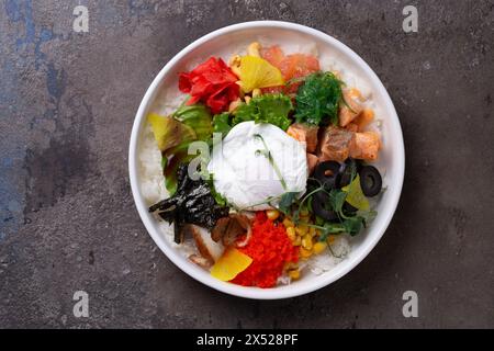Un bol à poke délicieux et sain rempli de saumon frais, un œuf dur et un assortiment de légumes colorés. Banque D'Images