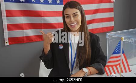 Une jeune femme hispanique avec un autocollant «j'ai voté», montrant le drapeau américain dans un collège électoral. Banque D'Images