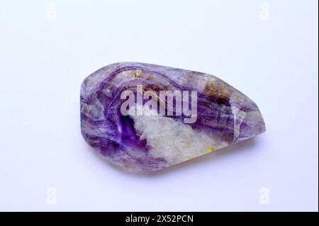 Gros plan sections de belle fluorite violette rayée sur un fond blanc. Cristaux de Chakra de guérison Banque D'Images