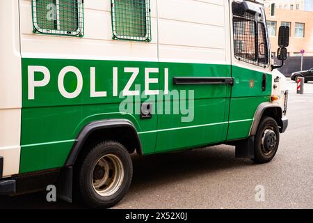 Autobus de police blanc et vert garé dans la rue à Berlin, symbole loi et ordre, réponse d'urgence, coopération internationale dans le maintien de sec national Banque D'Images