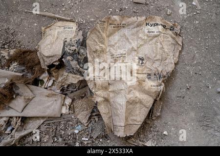 Restes d'un vieux journal kirghize de 1924 avec écriture cyrillique dans un bâtiment abandonné, ville fantôme, Engilchek, Tian Shan, Kirghizistan Banque D'Images