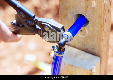 Le tuyau bleu de PVC est connecté au système de tuyauterie d'eau par le plombier Banque D'Images