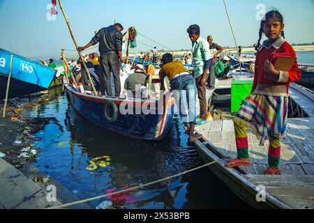 Un bateau rempli de pèlerins poussés de la rive dans le Gange à Varanasi, en Inde. Banque D'Images