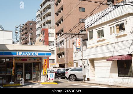 Fukuoka, Japon - 10 avril 2024 : Lawson dépanneur et rue résidentielle Banque D'Images