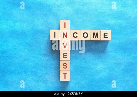 Investir le concept de financement du revenu. Mots croisés puzzle plat sur fond bleu. Banque D'Images