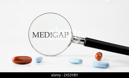 Concept médical. MEDIGAP sur fond blanc à travers une loupe Banque D'Images