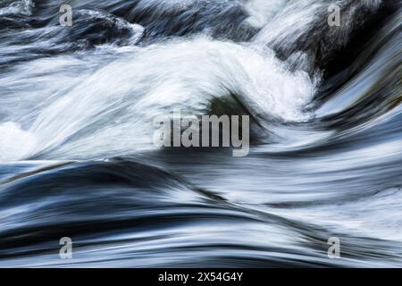 Une vitesse d'obturation lente ajoute du flou à une photographie d'eau courante dans un cours d'eau (Royaume-Uni) Banque D'Images