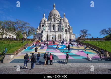 Paris, France. 7 mai 2024. Touristes appréciant le soleil chaud du printemps sur les marches peintes pour les jeux olympiques de la Basilique du Sacré-Cœur de Montmartre à Paris. Credit : amer Ghazzal/Alamy Live News Banque D'Images