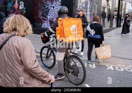 Just Eat Takeaway cycle de livraison le 7 avril 2024 à Londres, Royaume-Uni. Just Eat Limited est un service britannique de commande et de livraison de nourriture en ligne fondé en 2001. Il agit comme intermédiaire entre les points de vente indépendants de plats à emporter et les clients, avec des milliers de coursiers à vélo livrant la nourriture à vélo et par d'autres moyens de transport. Les GIG Workers sont des entrepreneurs indépendants, des travailleurs de plateformes en ligne, des travailleurs contractuels, des travailleurs sur appel et des travailleurs temporaires. Les travailleurs de GIG concluent des accords formels avec des entreprises à la demande pour fournir des services aux clients de la compagnie. Banque D'Images