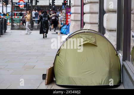 Tentes de sans-abri dressées en ligne sur le trottoir de Regent Street à Piccadilly Circus le 11 avril 2024 à Londres, Royaume-Uni. La scène illustre la disparité sociale au Royaume-Uni avec certaines personnes qui vivent dans une richesse relative par rapport à d'autres, et est un spectacle toujours coomon dans la capitale, alors que les gens luttent avec la crise du coût de la vie et les problèmes de santé mentale. Banque D'Images