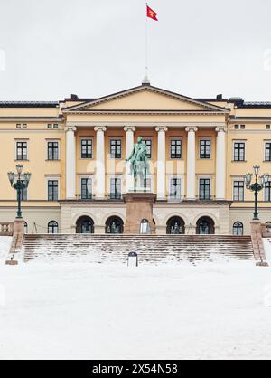 Façade du palais royal néoclassique d'Oslo en hiver avec vol royal norvégien standard et statue équestre du roi Carl Johan, Oslo, Norvège Banque D'Images