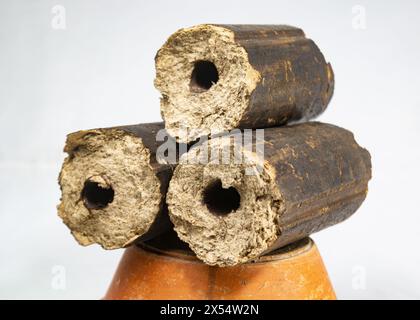 Charbons de bois, combustible solide renouvelable fabriqué à partir de la balle de riz. Cuisiner dans une fête de village sur un four temporaire en briques avec du combustible de briquette Rice Husk. Agro-RES Banque D'Images