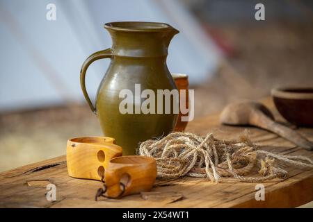 Cruche en céramique, bobine de corde et morceaux de bois gros plan, poterie sur une table en bois, mode de vie médiéval, nature morte. Photo de haute qualité Banque D'Images