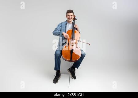 Jeune homme portant des vêtements décontractés jouant du violoncelle Banque D'Images