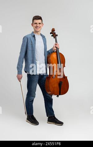 Jeune homme portant des vêtements décontractés jouant du violoncelle Banque D'Images