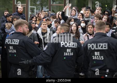 Berlin, Allemagne. 07 mai 2024. Des manifestants se tiennent devant des policiers à l'extérieur du camp lors d'une manifestation pro-palestinienne organisée par le groupe « Student Coalition Berlin » dans la cour du théâtre de Freie Universität Berlin. Les participants ont occupé la place avec des tentes mardi matin. Crédit : Sebastian Christoph Gollnow/dpa/Alamy Live News Banque D'Images