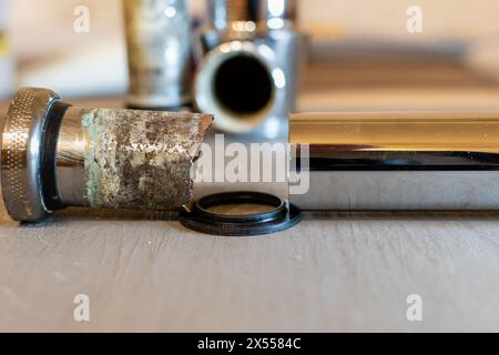 Siphon métallique de vidange gros plan avec des tuyaux rouillés recouverts de corrosion Banque D'Images