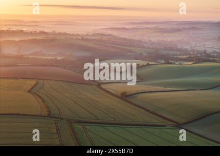 Belle aube printanière sur des terres agricoles vallonnées patchwork, Crediton, Devon, Angleterre. Printemps (avril) 2024. Banque D'Images