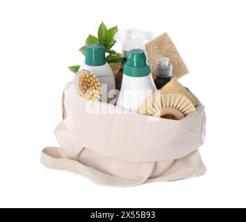 Bouteilles de produit de nettoyage, brosses, éponges et feuilles vertes dans un sac éco isolé sur blanc Banque D'Images