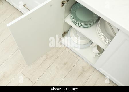 Nettoyez les assiettes et les tasses sur les étagères de l'armoire à l'intérieur Banque D'Images