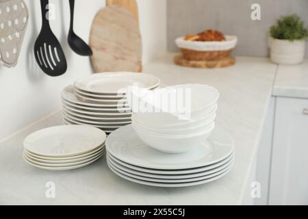 Nettoyez les assiettes et les bols sur le comptoir en marbre blanc dans la cuisine Banque D'Images