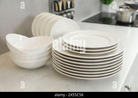 Nettoyez les assiettes et les bols sur le comptoir en marbre blanc dans la cuisine Banque D'Images