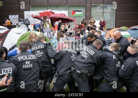 Berlin, Allemagne. 07 mai 2024. Des policiers prennent des mesures contre les manifestants lors d'une manifestation pro-palestinienne du groupe "Student Coalition Berlin" dans la cour du théâtre de Freie Universität Berlin. Des militants pro-palestiniens ont occupé mardi une cour de l'Université libre de Berlin. Crédit : Sebastian Christoph Gollnow/dpa/Alamy Live News Banque D'Images