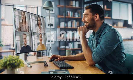 Beau spécialiste caucasien faisant un appel vidéo sur ordinateur de bureau à la maison salon tout en étant assis à table. Freelance travaillant à domicile et parlant à des collègues et des clients sur Internet. Banque D'Images