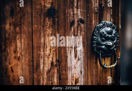 Antique Lion Head porte Knocker sur une porte en bois vieilli / Wuzhen Jiaxing Zhejiang Chine Banque D'Images