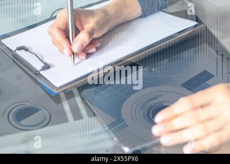 Gros plan de la femme avec de belles mains dans la tenue d'affaires, travaillant sur la tablette dans le bureau, prenant des notes. Graphiques de trading sur le foreg Banque D'Images