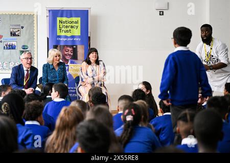 La reine Camilla rejoint le directeur général du National Literacy Trust Jonathan Douglas et la directrice de la primaire de Moreland Catherine Lawrence, alors qu'ils écoutent le rappeur et conteur britannique Sierra-léonais Alim Kamara à la salle d'Assemblée de l'école primaire de Moreland à Londres, lors d'une visite pour ouvrir leur nouvelle bibliothèque Coronation. la 50e d'une série de bibliothèques d'écoles primaires spéciales qui ont été transformées au cours des douze derniers mois avec l'aide du National Literacy Trust, pour marquer le couronnement. Date de la photo : mardi 7 mai 2024. Banque D'Images