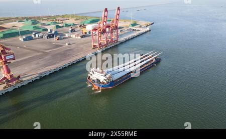 Un navire transportant des pales d'éoliennes part du port en direction du parc éolien offshore de la mer de Bohai. / GuangLi Port Dongying Shandong Chine Banque D'Images