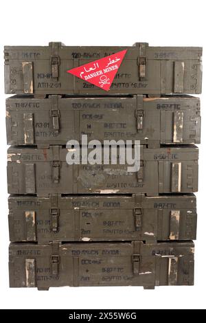 Avertissement de champ de mines arabe/anglais signe rouge - danger Mines sur la pile de munitions de l'armée soviétique de caisses vertes. Texte sur les caisses en russe - type d'ammuniti Banque D'Images