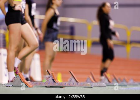 Jeunes sportives préparant à commencer le sprint sur un concours d'athlétisme en salle Banque D'Images