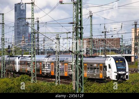 Rhein-Ruhr Express train régional et voies dans le quartier de la ville Deutz, dans le bâtiment de fond KoelnTurm à Mediapark, Cologne, Allemagne. Banque D'Images