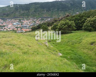 Vue aérienne sur la ville de Machico depuis le sentier de randonnée Levada do Canical. Sentier dans les collines verdoyantes et la végétation tropicale sur l'île de Madère, Portugal, Europe Banque D'Images