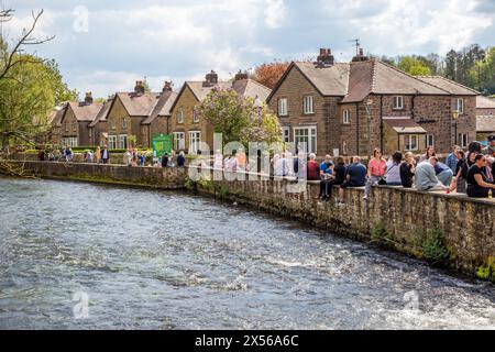 Les gens et les familles apprécient le soleil printanier et le temps ensoleillé sur les rives de la rivière Wye dans la ville de Derbyshire Peak District de Bakewell Banque D'Images