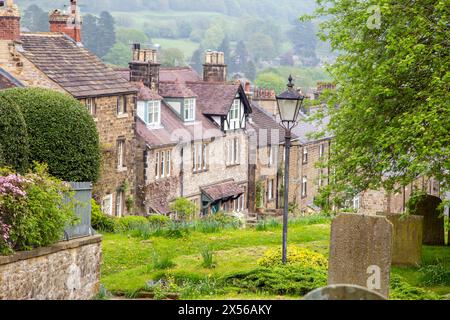 Vue des cottages en pierre du Derbyshire le long de North Church Street Bakewell , vue au-dessus du cimetière et des pierres tombales de l'église paroissiale All Saints Banque D'Images