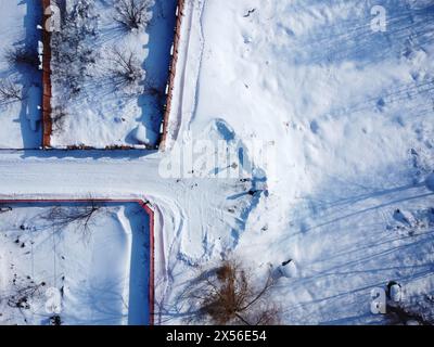 Vidéo hivernale d'un village par drone. Vue de dessus du sol enneigé Banque D'Images
