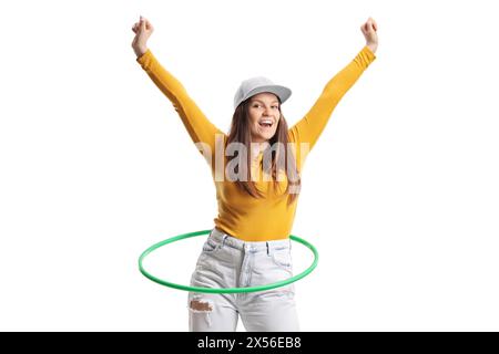 Heureuse jeune femme filant un hula hoop et levant les bras isolés sur fond blanc Banque D'Images