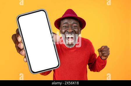 Homme afro-américain en chandail rouge tenant un téléphone portable Banque D'Images