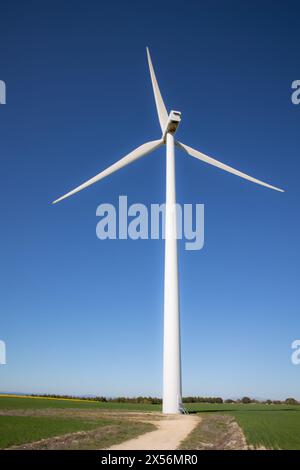 route de sable à côté d'un moulin à vent d'énergie éolienne au milieu de la campagne avec de belles couleurs et ciel bleu clair, énergie renouvelable Banque D'Images