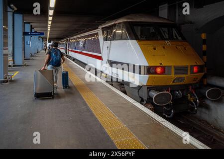 Passager de Kings Cross Station prenant un train de Londres à Leeds. Le train classique Intercity 225 Londres-Leeds de LNER à la gare de Kings Cross. Banque D'Images