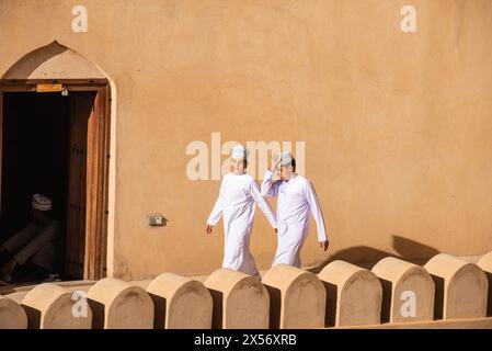 Garçons avec des chapeaux kuma sur le toit, Nizwa, Oman Banque D'Images