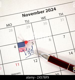 L’élection présidentielle AMÉRICAINE aura lieu le 5 novembre 2024. Un calendrier avec une épingle un drapeau américain et le texte "vote!" Le 5 novembre. Une lyine de stylo Banque D'Images