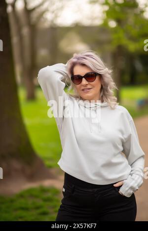 Femme élégante avec des cheveux argentés dans le parc. Banque D'Images