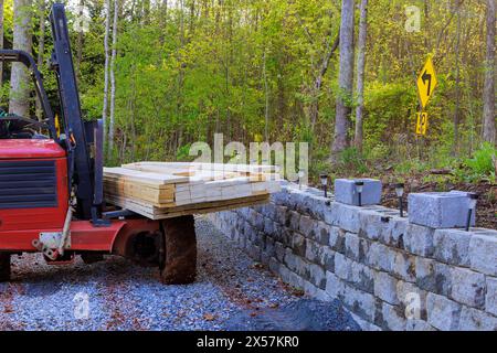 À l'aide d'un chariot élévateur, l'entrepreneur livre des matériaux de construction sur le chantier de construction Banque D'Images