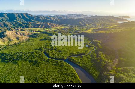 Vue aérienne d'une rivière sinueuse serpentant à travers un paysage vallonné verdoyant, Pochote, Puntarenas, Costa Rica Banque D'Images