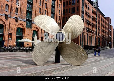 Musée maritime international, Koreastrasse, Hafencity, Hambourg, Une grande hélice de navire devant des bâtiments historiques en briques sur une promenade urbaine Banque D'Images